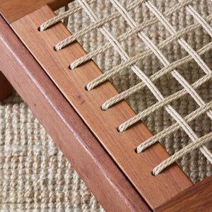 Artistic mood image looking down on to woven Danish cord on a Scandinavian stool made of solid teak wood.