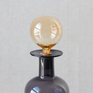 Close up of a yellow ball stopper in a purple Kaj Franck decanter belonging to a Kremlin Bells decanter and pitcher set, for sale in London from design gallery Art & Utility.