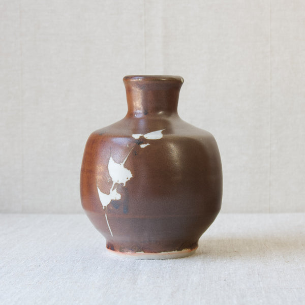 A British Studio Pottery vase by Jim Malone, handmade in his Ainstable studio, Cumbria, England. The vase features a Japanese Kaki glaze with wax resist reeds decoration. 