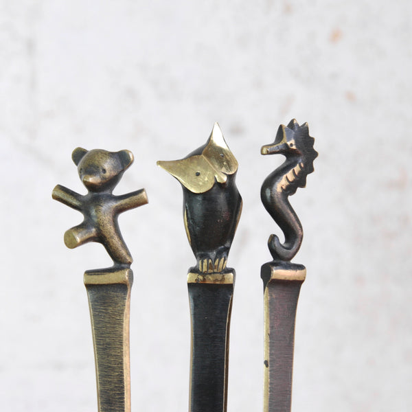 Three decorative Austrian bronze letter opener desk accessories, each adorned with a different animal on the end. From left to right; a bear cub, a wise owl, and a seahorse. All 3   of the hand-crafted Modernist designs are by Walter Bosse and produced by Herta Baller, available worldwide from Art & Utility.