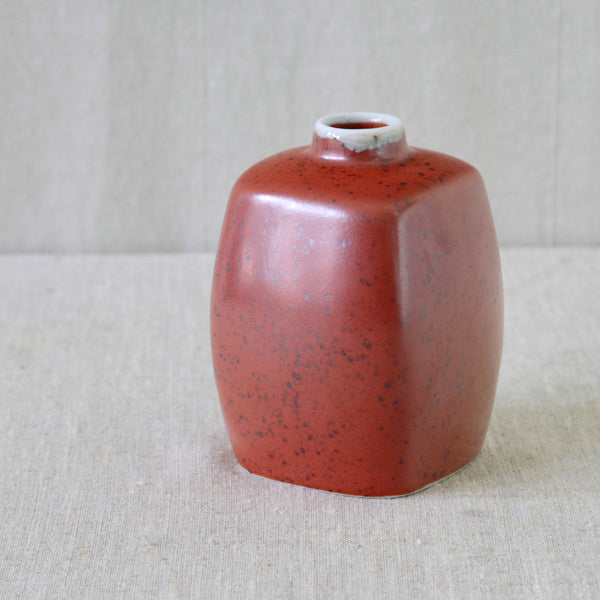 Close-up of sculptural Nils Thorsson vase in vivid red-orange speckled jernrød glaze
