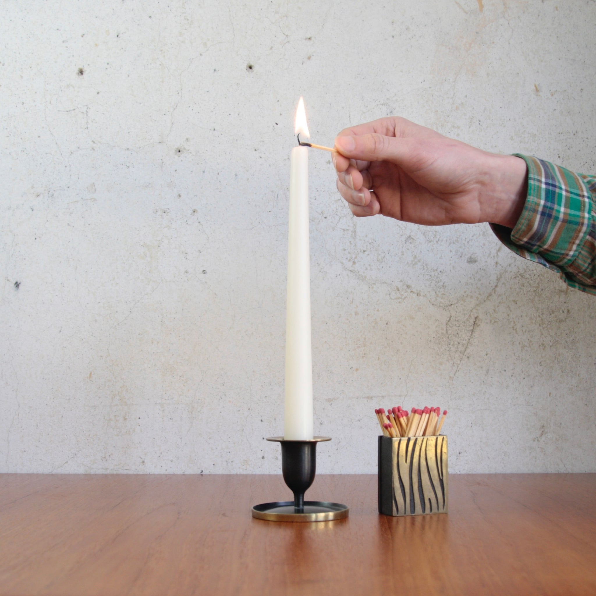 Handcrafted by Richard Rohac in Austria during the 1950s, this brass candle holder is a fine example of modernist Viennese metal artistry. Paired with Walter Bosse tiger stripe matchbox holder.