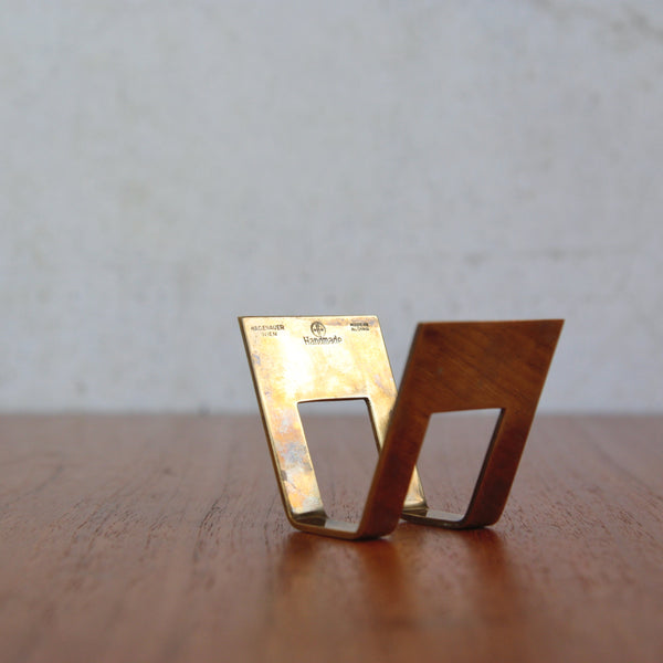 Rare 1950s Karl Hagenauer brass card holder, collectible modernist desk accessory. Background is blurred.