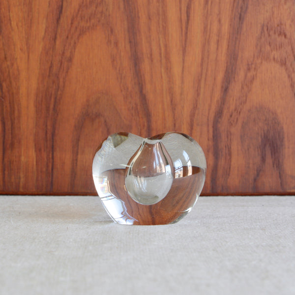 Elegant clear glass vase designed in 1953 by Timo Sarpaneva. The organic shape gently takes the form of a heart, and suspended within floats a small cavity to take a stem of a small flower. This is an excellent example of Sarpaneva's artistic capabilities, exploiting the unique liquid properties of the medium of glass to create an object of poetry.