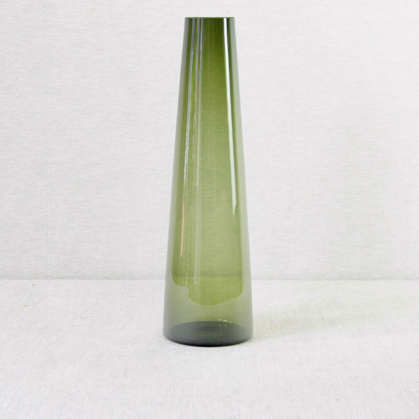 A tall and sleek, model 1404 or SH 105, green glass vase on a white background. Designed by Saara Hopea in 1953 for Nuutajärvi Notsjö, Finland. Height 31 cm, this is the tallest version of this vase. Early mid-century Modern Finnish glass for sale in the UK from Nordic design gallery Art & Utility.