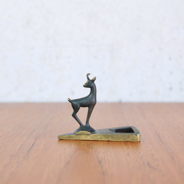 Richard Rohac brass bottle opener with triangular handle and sculptural alpine goat figure.