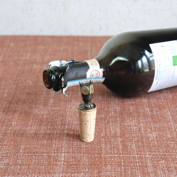 Mid-century modern owl bottle stopper by Walter Bosse for Herta Baller, Vienna. Brass and cork design with black patina and golden eyes.