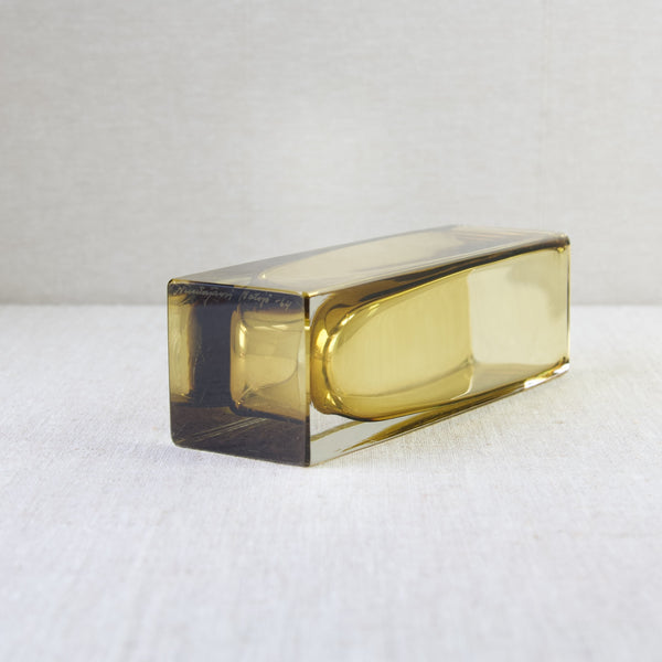 Image of a model 296 vase in amber yellow laying on its side. The design is by Kaj Franck for Nuutajärvi Notsjö. This example was made in the first year that the design was produced, 1964.