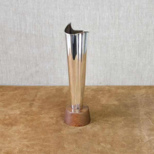 A Tapio Wirkkala solid silver vase on a teak wood base. One of the leading proponents of Modernism, Wirkkala often found inspiration in nature and the frozen wilderness of northern Finland. This item is commonly refered to as the "Flame" vase.
