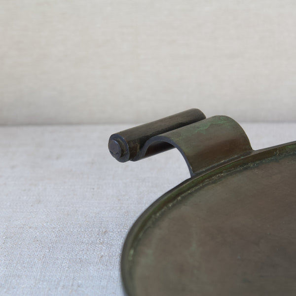 Detail of a flowing scroll handle on an Einar & Sune Bäckström Swedish Grace bronze platter or charger