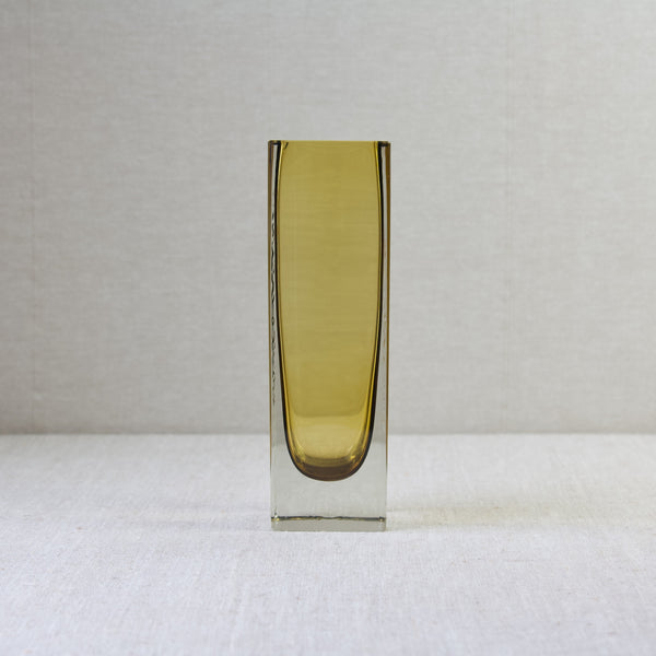 Head on shot of the flat sided face of a square shaped model 296 vase designed by Kaj Franck for Nuutajärvi Notsjö. The summerso design is in yellow and clear glass.