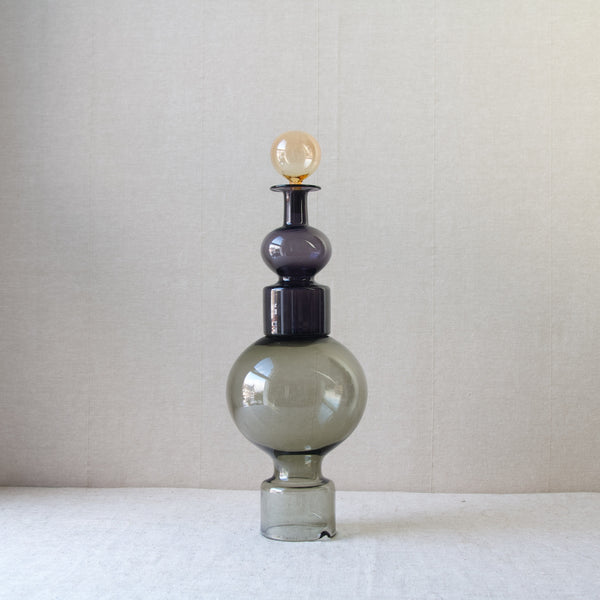 A playful image showing a 'Kremlin Kellot' or 'Kremlin Bells' decanter stacked incorrectly. This prized example of Scandinavian Modernist glass was made by Nuutajärvi Notsjö who employed glassmakers from Italy to achieve their excellent colours. Design by the artistic director of Nuutajarvi glassworks, Kaj Franck.