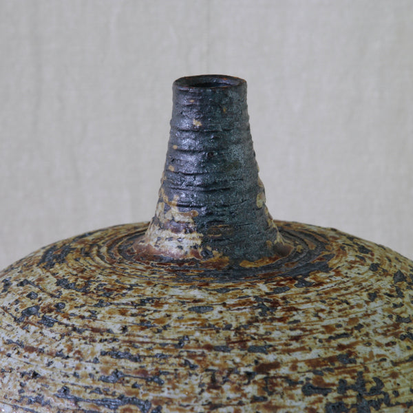 Detail of iron glaze on impressively large vase handmade by Annikki Hovisaari for Arabia Finland, with a tapered neck and highly textured surface.