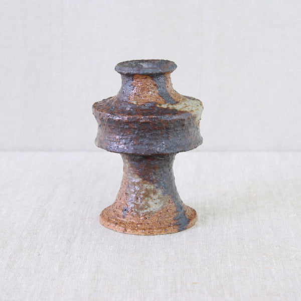 Textured clay vase by Annikki Hovisaari, with exposed chamotte and layers of earthy rust and brown glaze.