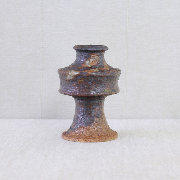 Geometric Space Age vase by Annikki Hovisaari, its futuristic UFO-like silhouette contrasting with earthy textured clay.
