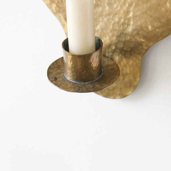 Quaint and charming brass wall sconce, reminiscent of a bygone era of craftsmanship.