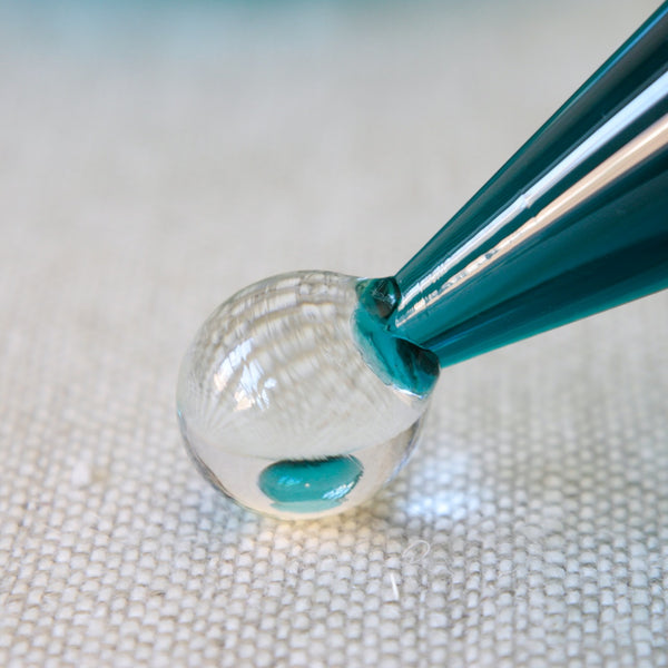 Clear glass ball knob on lid of a Riihimäen Lasi Harlekiini glass bowl designed by Nanny Still, an enduring symbol of Finnish Modernism.