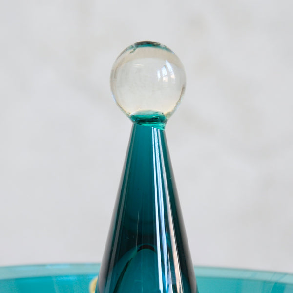 Harlekiini teal glass lid with a clear spherical top knob on a white background. Design by Nanny Still.