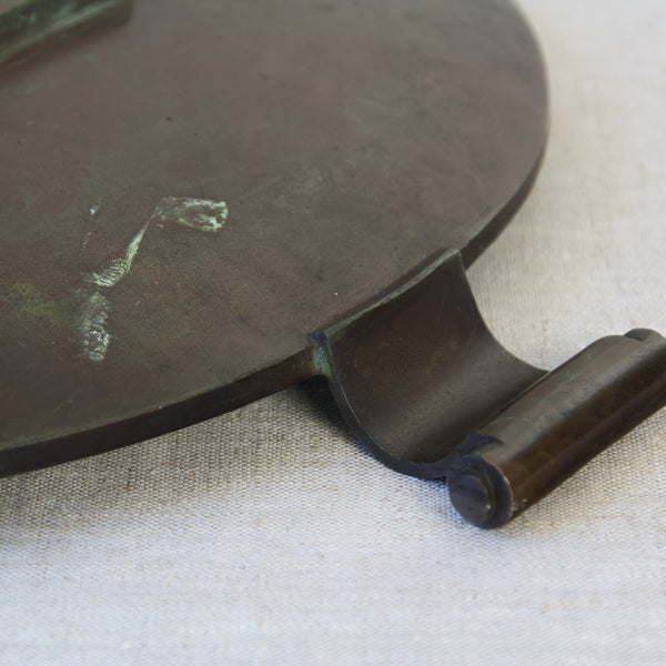 Zoomed in image showing the beautiful way in which scrolling handles attach to a circular dish. The design is by Einar & Sune Bäckström, who made Swedish Grace bronze accessories in the 1930s.
