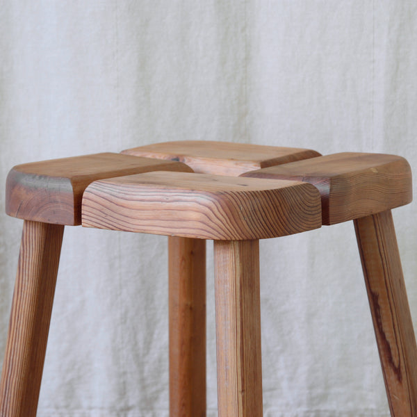 Detail of expressive pine grain on a vintage Olof Ottelin stool, a compact piece of Scandinavian Modern furniture equally suited as a stool or small side table.