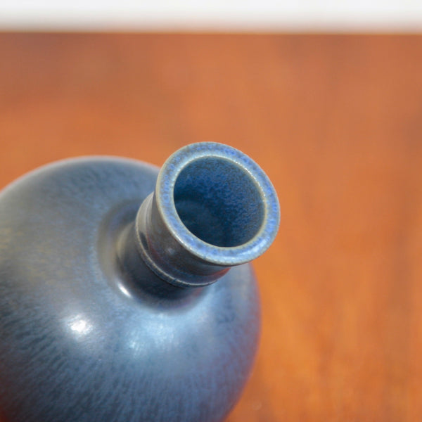 Close-up of a mouth and rim of a blue ceramic vase. Detail of the glaze texture on Wilhelm Kage’s Gustavsberg piece showing subtle gradations of blue and hare’s fur effects prized by Scandinavian design collectors.