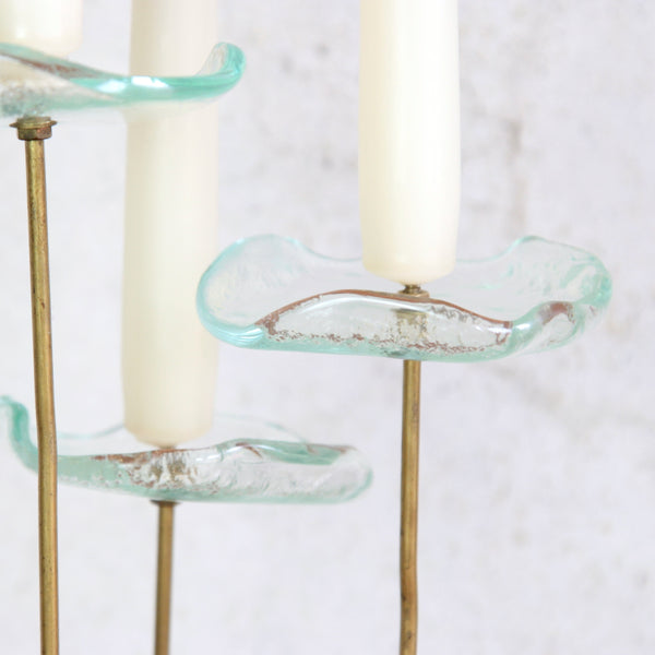 Abstract detail image of an organic mid-century candle holder in brass and glass, a collectible Scandinavian design.