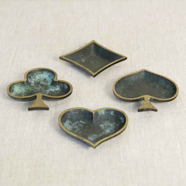 A set of rare brass ashtrays, each shaped like a playing card suit, bearing the stamp 'M.I. Germany', great mid-20th-century craftsmanship.