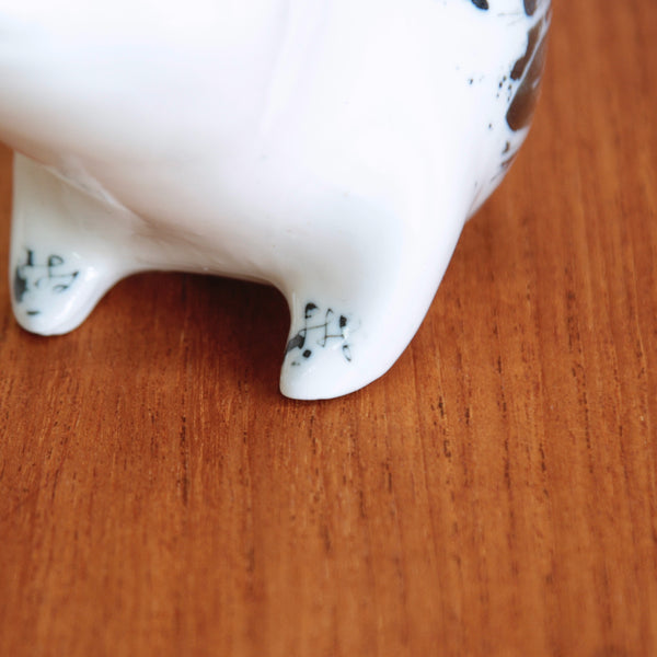 Close up of the delicately decorated foot of a Susan Parkinson seated bear money bank, hand-decorated using sgraffito technique, 1950s.