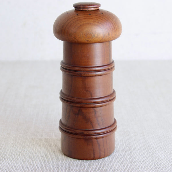 Close up of tiger stripe like wood grain on a Scandinavian modern teak pepper mill designed by Jens Quistgaard for Dansk Designs