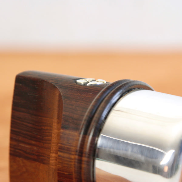 Close-up of a sculptural functional pepper mill by Jens Quistgaard for Dansk Designs, combining rosewood and silver.