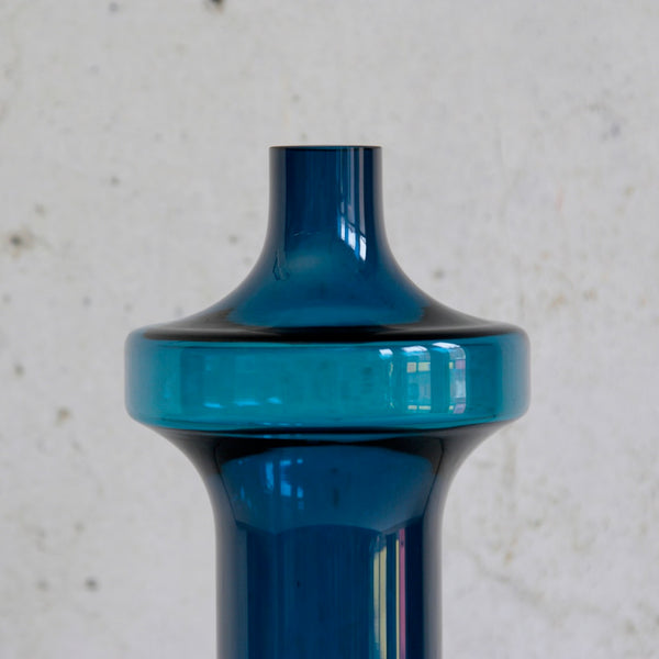 Blue glass vase against a light gray background. Vintage mid-century Scandinavian Katedraali vase by Helena Tynell, Riihimäen Lasi.