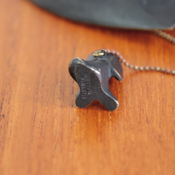 Detail showing the underside of a small dog figurine designed by Walter Bosse. The animal is tethered to a small boat. The mid-century design was produced by Herta Baller and her makers stamp is marked on the base. AUSTRIA, BALLER.