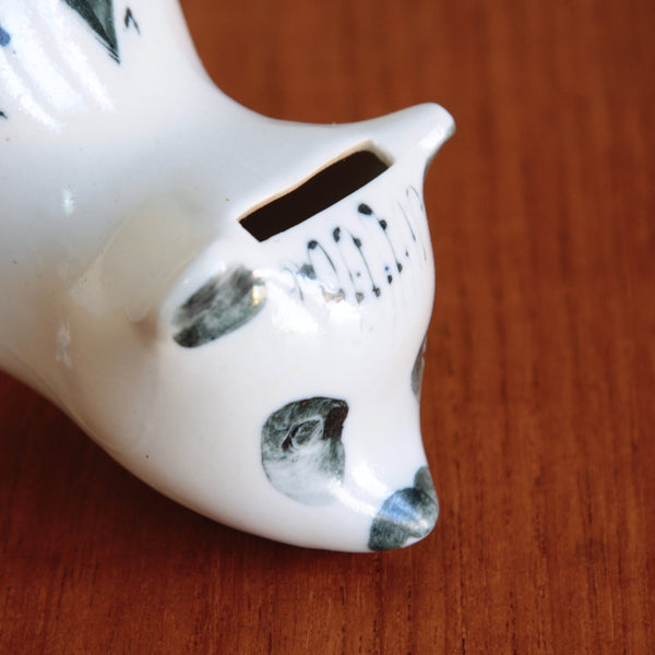Close up showing the slot where money is inserted on a piggy bank. This container is a Susan Parkinson collectible bear money box, available for sale in the UK from Art & Utility.