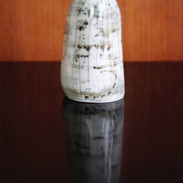 Close up of the bottom of a Susan Parkinson cat sculpture, complete with a tail painted with fluid lines.