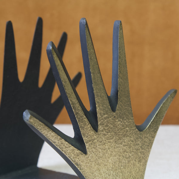 Detail of polished brass hand bookends by Walter Bosse