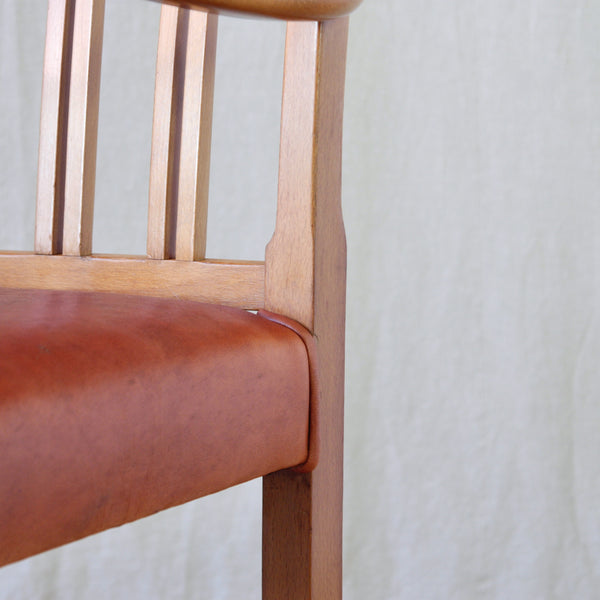 Detail of piping on Ole Wanscher red leather and beech armchair, an elegant early example of the designer's work for Fritz Hansen, Denmark.