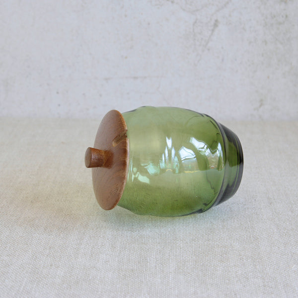 Scandinavian Modern storage jar designed by Erik Höglund for Boda, featuring a wooden lid and a a hand-blown glass body in the form of a barrel.