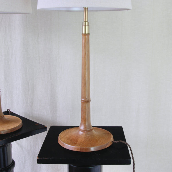 Close view of an Esben Klint Model 301/27 lamp showing the warm oak grain, turned stem and incised bamboo-like collars.