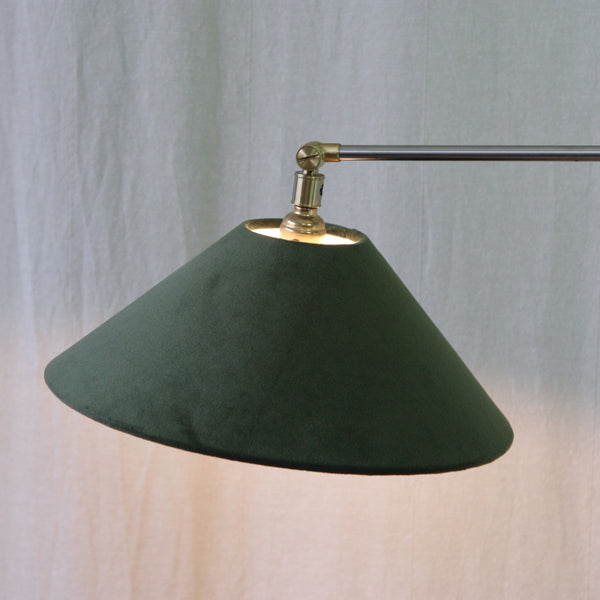 A dark green velvet fabric conical lampshade on an Esben Klint Model 319 lamp, contrasting with the precise stainless-steel and brass metalwork.