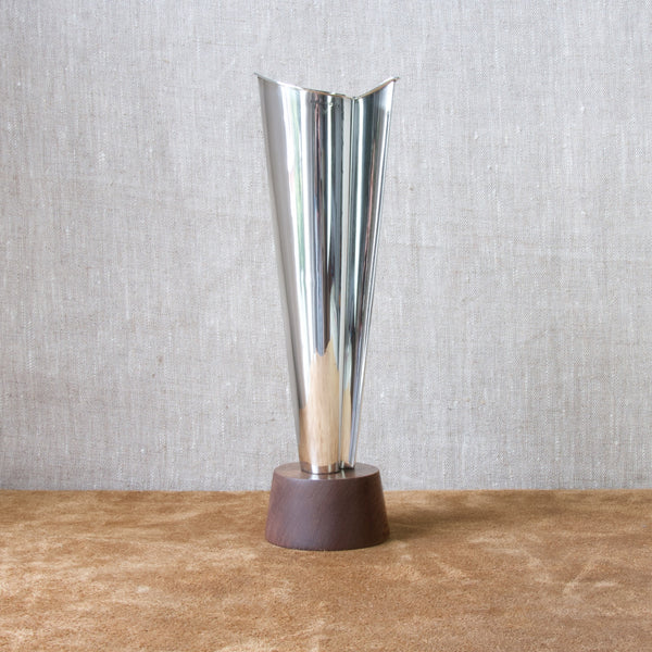 Head on shot of a tall silver vase design by Tapio Wirkkala. The form is triangular but also organic. A brilliant example of post second world war Scandinavian design.