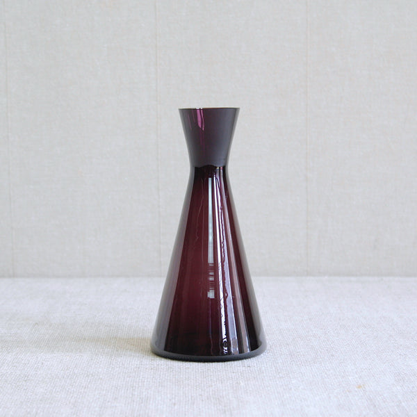 A conical geometric vibrant tyrian purple glass vase or carafe designed by Kaj Franck in 1954 for Nuutajärvi Notsjö, Finland.This sleek and richly coloured collectible mid-century modern design belongs to the ‘1541’ series.