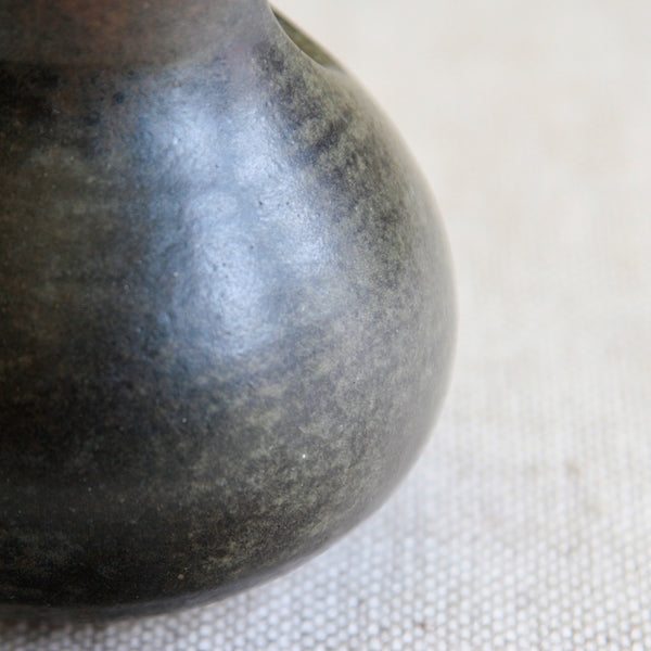 Close-up of a mottled dark brown, grey, green ceramic vase by Francesca Mascitti Lindh. This Modernist design was handmade in Finland and is admired by collectors of Scandinavian studio pottery.
