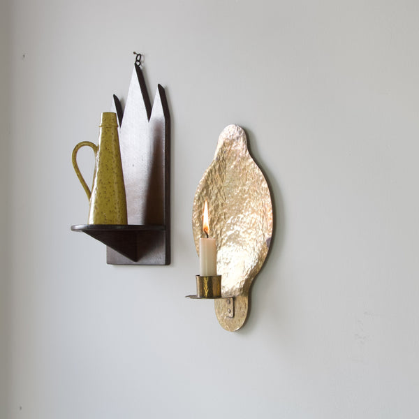 Mood image of two wall sconces. One candle holder and one shelf. Artisanal brass wall sconce, lovingly crafted with attention to detail, from the mid-20th century.