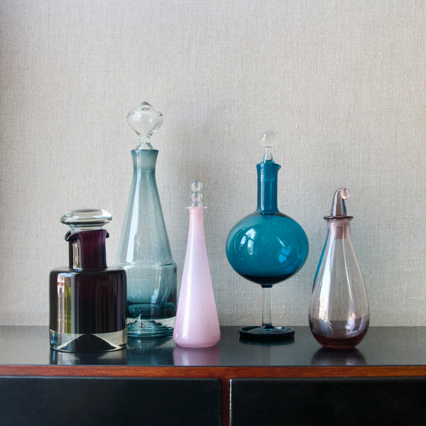 Group image of Nanny Still modernist glass decanters including Paraati, Tzarina, Harlekiini & SV designs. Each decanter was made at Riihimaki, Finland. 