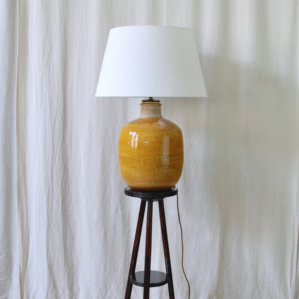 Nils Kähler ceramic table lamp showing its unusually large rounded body and highly reflective yellow-ochre glazed surface.