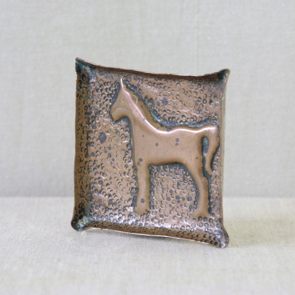 Handmade hammered brass horse tray, naïvely crafted in England circa 1950 with a stylised repoussé horse at its centre.