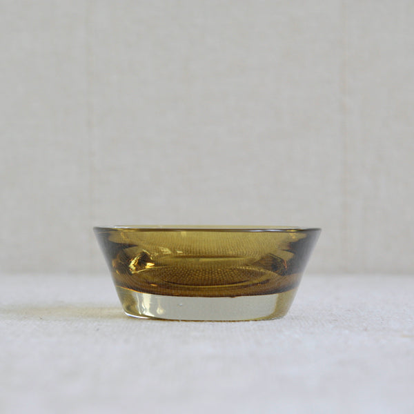 A short amber glass bowl that could be used as a candleholder designed in 1956 by Saara Hopea for Nuutajärvi Notsjö, Finland.