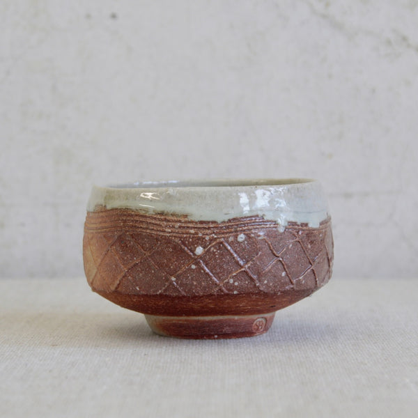 Handmade tea bowl by Phil Rogers with salt-glazed exterior and rich white nuka glaze inside and around the rim.