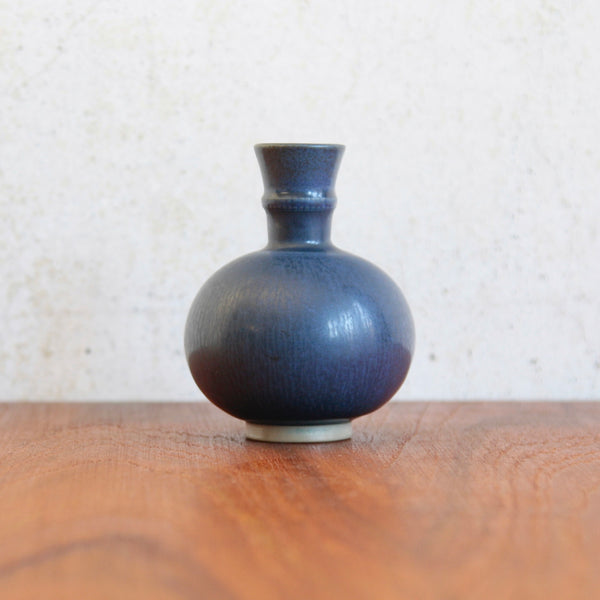 Straight on shot of Wilhelm Kage’s collared bottle vase with carvincised lines around its collar, a unique Nordic interpretation of East Asian ceramic forms.