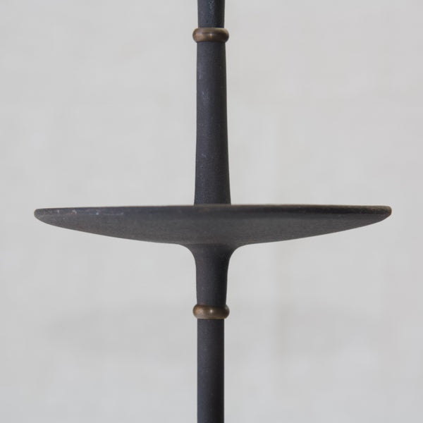 Head on shot of the slender sculpted "Satellite" dish for catching dripping wax on a tall cast iron dansk designs candlestick designed by Jens Harald Quistgaard in the 1960s.